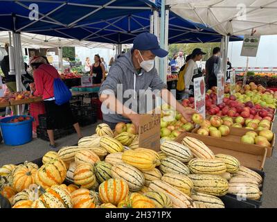 Worker arrangiert Obst und Gemüse zum Verkauf auf dem Grand Army Plaza Farmers Market am Rande des Prospect Park in Brooklyn, New York. Stockfoto