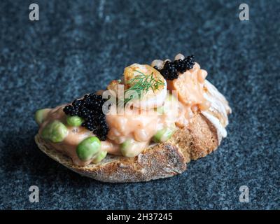 Knusprig gebackenes Brot mit Garnelensalat und Edamame-Bohnen mit Kaviar und Dill Stockfoto