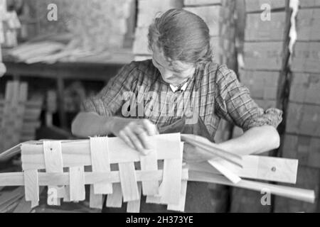 Arbeiterin in der Bühler Spankorbfabrik, sterben sterben sterben Körbe für die Erdbeerernte liefert, Deutschland 1930er Jahre. Arbeiterin in der Fabrik gebäude der Korb Fabrik, die Herstellung der Körbe für die Erdbeere Ernte in Bühl, Deutschland 1930. Stockfoto