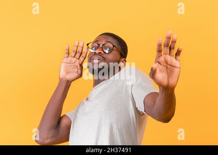 Angewiderter schwarzer Mann, der mit Händen eine ablehnende Geste zeigt, verängstigter Kerl, der sich von etwas fernhält Stockfoto