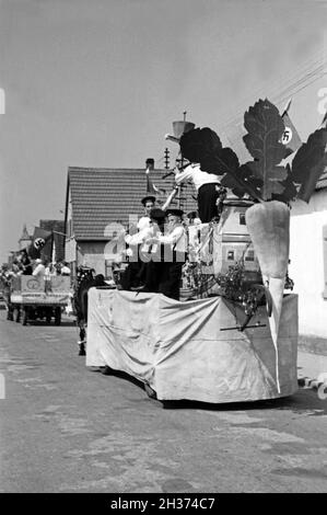 Pferdefuhrwerke im Festzug zum Rettichfest in Schifferstadt, Deutschland, 1930er Jahre. Pferdekutschen am Pageant der jährlichen Rettich Messe in Schifferstadt, Deutschland 1930. Stockfoto