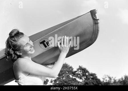 Junge Frau im Badeanzug trägt ein Boot/Klepper T6, Deutschland 1930er Jahre. Junge Frau im Badeanzug mit einem Boot/Klepper T6, Deutschland 1930. Stockfoto