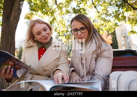Reife Frau studyiong mit ihrem Freund im Freien im Park Stockfoto