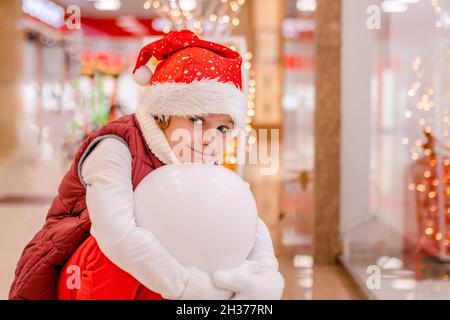 Boys in Santas Hut schaut durch das Fenster auf dem Markt in den Laden. Platz zum Kopieren, Platz für Text, Banner Stockfoto