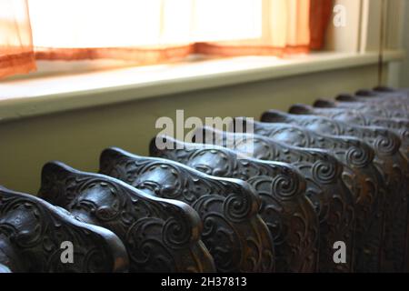 Nahaufnahme eines alten Heizkörpers am Fenster Stockfoto