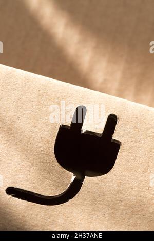 Elektrisches Steckersymbol auf Kartonverpackung ausgeschnitten Stockfoto