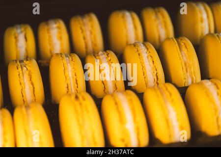 Schöne gelbe Macarons in Geschenkschachtel Stockfoto
