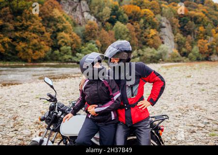 Ein paar Biker fahren im Herbst mit dem Motorrad. Motorradfahrer genießen die herbstliche Landschaft in den Bergen und ruhen sich im Wald aus Stockfoto