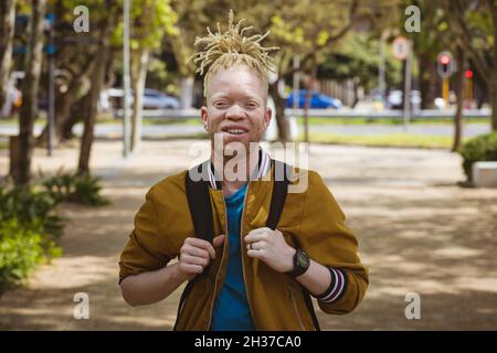 Porträt eines lächelnden afroamerikanischen Albino-Mannes mit Dreadlocks, der die Kamera anschaut Stockfoto