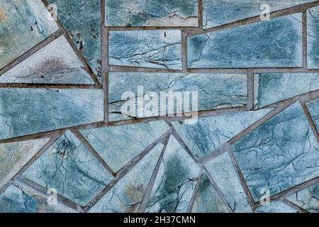 Bodenfläche aus Granit oder Marmorfliesen in verschiedenen Formen. Fliesen in chaotischer Reihenfolge angeordnet. Stockfoto