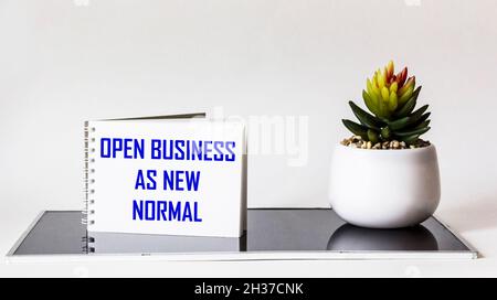 ÖFFNEN SIE DAS GESCHÄFT WIE NEU, Text auf Notizblock und weißem und schwarzem Hintergrund. Stockfoto