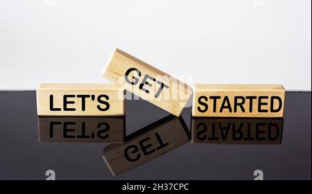Lassen Sie uns beginnen Text auf Holzblock und schwarz-weißen Hintergrund. Business-Konzept Stockfoto