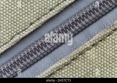 Ein Makrofoto eines Reißverschluss auf einem dicken Khaki-Stoff, Hintergrund Stockfoto
