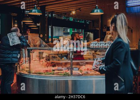 London, Großbritannien - 17. Oktober 2021: Frisches Fleisch und Geflügel stehen auf dem Borough Market, einem der größten und ältesten Lebensmittelmärkte in London, Menschen gehen zu Fuß pa Stockfoto