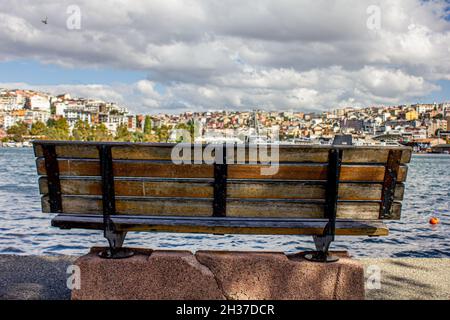 Fatih, Istanbul, Türkei-Oktober-Mittwoch-2021: Eine leere Bank und graue Wolken am Ufer des Goldenen Horns Stockfoto