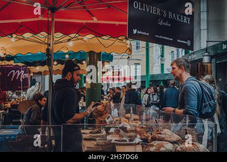 London, Großbritannien - 17. Oktober 2021: Menschen am Olivers Bakery Stall am Borough Market, einem der größten und ältesten Lebensmittelmärkte in London, selektiver Fokus Stockfoto