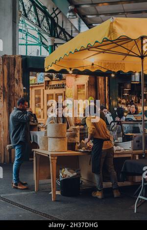London, Großbritannien - 17. Oktober 2021: Menschen an einem Käsestand im Borough Market, einem der größten und ältesten Lebensmittelmärkte Londons. Stockfoto