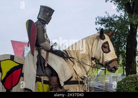 Stadtfest in Europa. Gepanzerter Ritter auf dem Pferderücken. Stockfoto