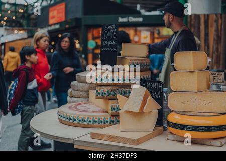 London, Großbritannien - 17. Oktober 2021: Verschiedene Käseräder sind an einem Stand im Borough Market, einem der größten und ältesten Lebensmittelmärkte in London, erhältlich. Stockfoto