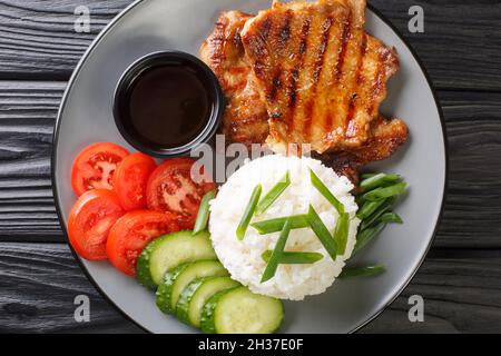 Broken-Reis-Rezept mit gegrilltem Schweinefleisch Chop close-up auf einem Teller auf dem Tisch. Horizontale Draufsicht von oben Stockfoto