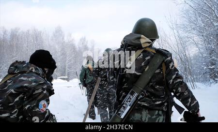 Gruppe von Spezialeinheiten Waffen im kalten Wald. Clip. Soldaten bei Übungen im Wald im Winter. Winterkrieg und militärisches Konzept Stockfoto