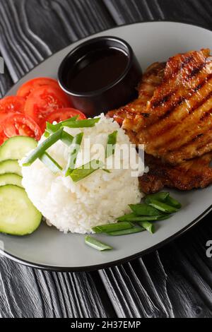 Authentische vietnamesische Broken Rise Com Tam Rezept mit gegrilltem Schweinefleisch Nahaufnahme in einem Teller auf dem Tisch. Vertikal Stockfoto