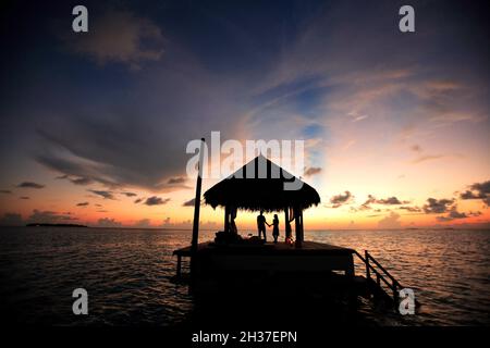 MALEDIVEN-INSELN, SÜDMÄNNLICHES ATOLL, DAS TAJ EXOTICA HOTEL. SONNENUNTERGANG AUF DEM PONTON Stockfoto