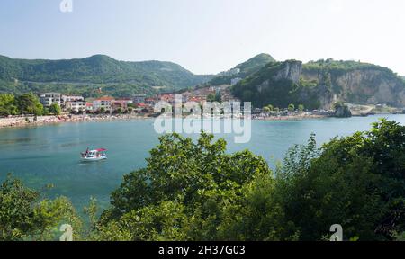 Sommer am Amasya Strand. Bootsfahrt mit Menschen und Stadtbild Stockfoto