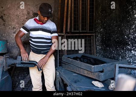 (211026) -- WAKISO, 26. Oktober 2021 (Xinhua) -- Wilbert Twinomujuni, ein Lehrer, entfernt Briketts aus der Kompressormaschine in einer Werkstatt in der St. Kizito High School in Namugongo, Wakiso District, Uganda, 14. Oktober 2021. UM ZU SAGEN: „Feature: Ugandische Lehrer greifen auf Überlebensfähigkeiten zu, da Schulen wegen COVID-19 geschlossen bleiben“ (Foto: Hadarah Nalwadda/Xinhua) Stockfoto