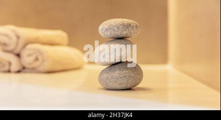 Zen-Steine, glatte Kieselsteine Pyramide gestapelt Gleichgewicht, Spa-Innenraum Hintergrund. Ganzheitliches Naturtherapie- und Wellnesskonzept Stockfoto