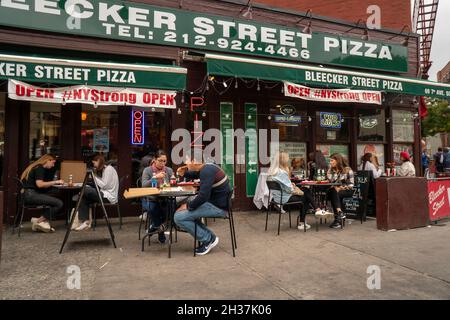 Hungrige Pizzaliebhaber essen am Samstag, den 9. Oktober 2021, außerhalb der beliebten Bleecker Street Pizza im Stadtteil Greenwich Village in New York. (© Richard B. Levine) Stockfoto