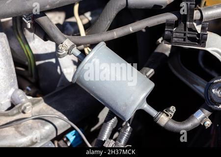 Kraftstofffilter in einem Fahrzeug mit einer Kraftstoffleitung, die unter der geöffneten Haube angeschlossen ist, eingebaut. Filterelement in der Kraftstoffleitung, das Schmutzpartikel und abfängt Stockfoto