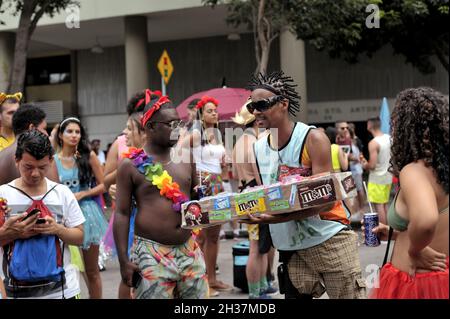 Brasilien, 22. Februar 2020: Ein Straßenhändler verkauft M&M's Candy sowie andere Süße während einer Straßenkarnevalparade in der Innenstadt von Rio de Janeiro Stockfoto