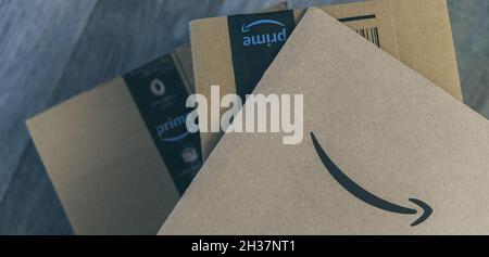 Boxen mit Amazon-Logo auf dem Boden. Bestellung bei Lieferung. Weihnachtsgeschenke im Karton bereit zum Öffnen. Amazon Prime Priority Delivery E-Commerce Stockfoto