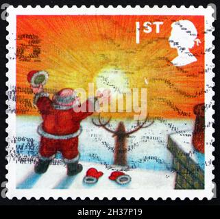 GROSSBRITANNIEN - UM 2004: Eine in Großbritannien gedruckte Briefmarke zeigt den Weihnachtsmann, der die aufgehende Sonne, Weihnachten, um 2004 betrachtet Stockfoto