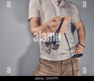 Mann, der den Stecker in der Hand hält Stockfoto