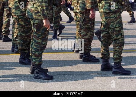 Soldaten der griechischen Armee in Kampfuniform während der Parade. Silhouette der Männer der hellenischen Streitkräfte, die schwarze Stiefel und Kampfkleidung in einem Tarnmuster tragen. Stockfoto