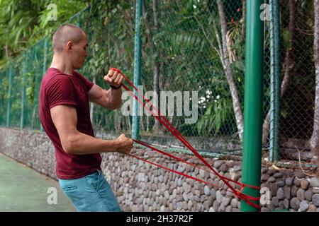 Ein Mann, der Gummibänder macht. bali Stockfoto