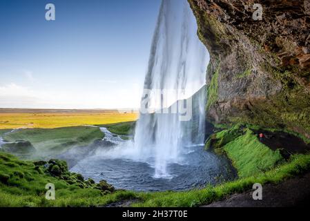 Wandern hinter dem Seljalandsfoss Wasserfall im Sommer, Island Stockfoto