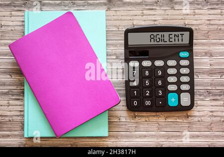 Agiler Text, der zusammen mit Notizbüchern auf einem Taschenrechner-Display und auf einem Holzbrett geschrieben wurde. Geschäftskonzept zur Entwicklung der Fähigkeit zur technologischen ch Stockfoto