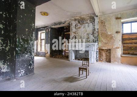 Stuhl im Loft-Stil Zimmer, Kamin im Hintergrund, schäbige Wände. Hochwertige Fotos Stockfoto