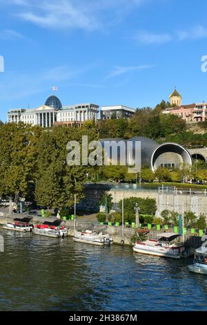 Tiflis, Georgien - 24. Oktober 2021: Das Panorama der georgischen Hauptstadt mit dem Fluss Kura, dem Präsidentenpalast, Tbilisi Music Theatre und Konzert Stockfoto