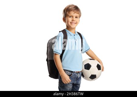 Netter Schuljunge mit einem Rucksack, der einen Fußball auf weißem Hintergrund isoliert hält Stockfoto