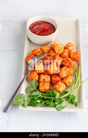 Gebratene Kartoffelbites mit Ketchup auf einer Platte Draufsicht Vegetarischer Vorspeise Foto Stockfoto