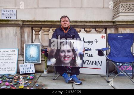 London, Großbritannien. Oktober 2021. Richard Ratcliffe zeigt während des Hungerstreiks ein Bild seiner Frau Nazanin Zaghari-Ratcliffe.Richard Ratcliffe, der Ehemann des britisch-iranischen Hilfsarbeiters Nazanin Zaghari-Ratcliffe, setzt seinen Hungerstreik vor dem Außenministerium in Whitehall fort und fordert die britische Regierung auf, mehr zu tun, um bei ihrer Freilassung zu helfen. Nazanin Zaghari-Ratcliffe ist seit 2016 im Iran inhaftiert, weil er angeblich Propaganda gegen die iranische Regierung verbreitet hat. Kredit: SOPA Images Limited/Alamy Live Nachrichten Stockfoto