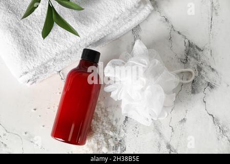 Flasche Duschgel, saubere Handtücher und Schwamm auf hellem Hintergrund Stockfoto