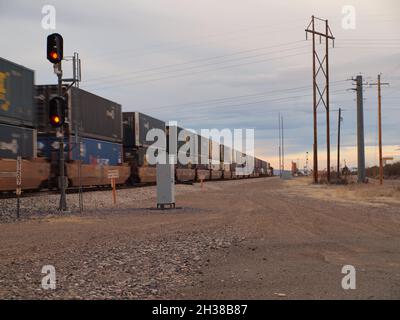 Union Pacific Zug durch den amerikanischen Südwesten in Deming, New Mexico. Sowohl geschlossene Autoträger als auch Container werden mit Geschwindigkeit in Richtung Westen gezeigt. Stockfoto