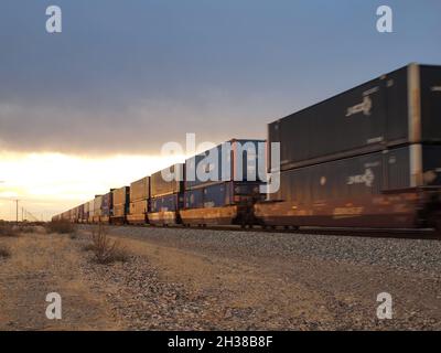 Union Pacific Zug durch den amerikanischen Südwesten in Deming, New Mexico. Sowohl geschlossene Autoträger als auch Container werden mit Geschwindigkeit in Richtung Westen gezeigt. Stockfoto