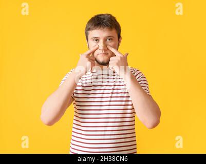 Mann mit medizinischem Fleck auf der Nase vor farbigem Hintergrund Stockfoto