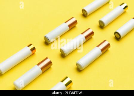 Alkali-Batterien in Reihen auf gelbem Hintergrund Stockfoto
